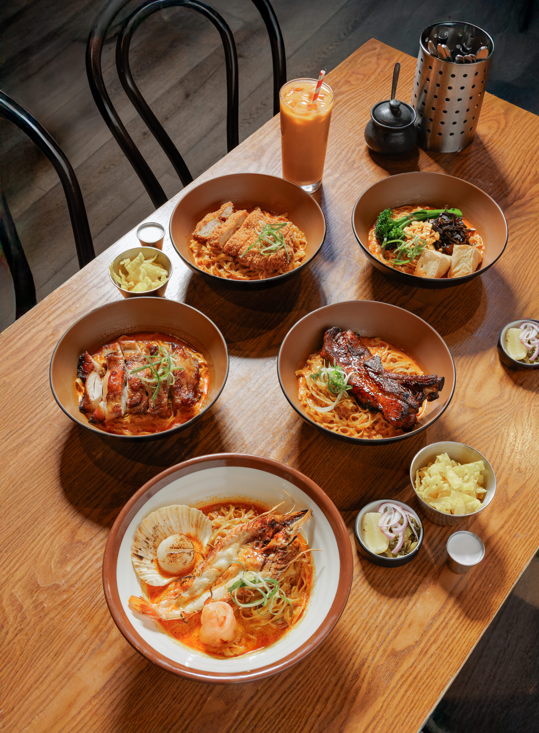 Khao Soi bowls served on a wooden table at Khaosoi Sydney